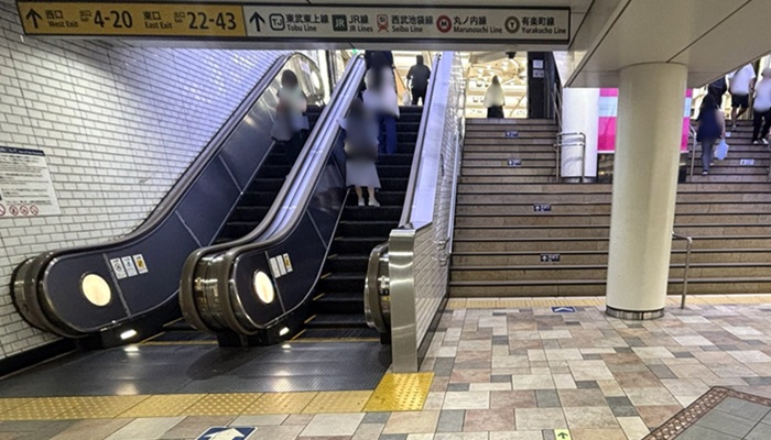 池袋駅の地下の副都心線通路からルミネ・JR改札がある地下1階へ上がるエスカレーターと階段。案内板に西口・有楽町線・東武線などの表示がある
