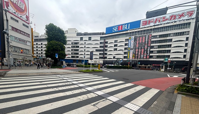 池袋駅35番出口を出た裏手にある池袋駅東口交差点。正面に西武百貨店・ヨドバシカメラの建物と大きな横断歩道が見える様子