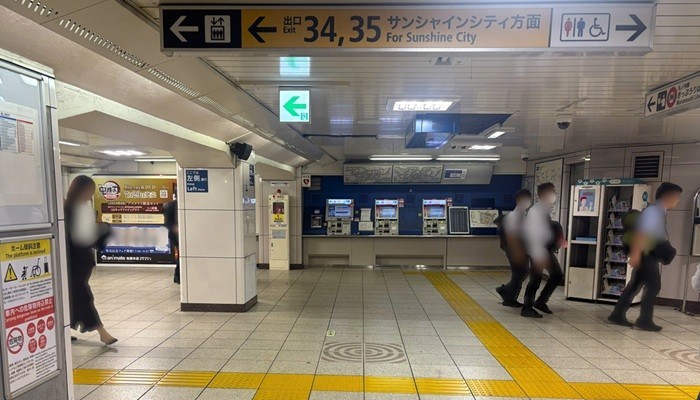 池袋駅地下通路。正面の丸ノ内線きっぷ売り場手前で『34, 35 サンシャインシティ方面』の案内板に従い左へ曲がる様子