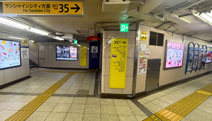 池袋駅35番出口手前の分岐。右が35番出口通路、中央奥には地上行きエレベーターの案内